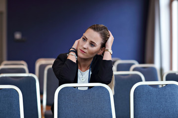 Young woman sitting alone in conference room