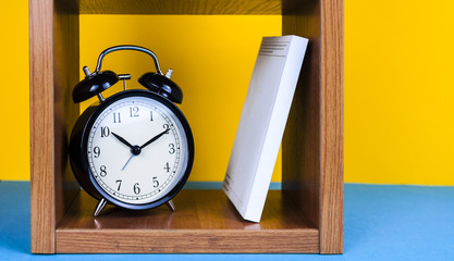 Alarm clock and book on the bookshelf