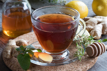 A cup of tea with ginger, lemon, herbs and honey