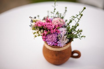 Clay pot with pretty bouquet of flowers