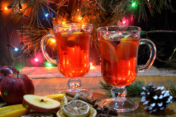 Mulled wine in glasses with spices on wooden table