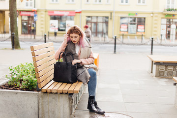 Girl sit on the bench and wait for her friends