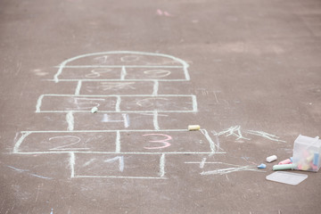 Closeup of hopscotch drawn with chalk on asphalt road. Children games and outdoor activities.