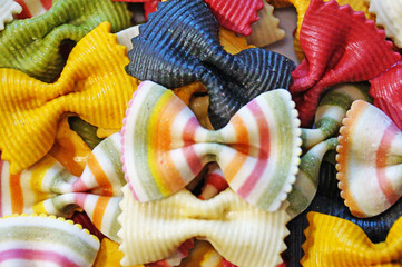 Macaroni background. Beautiful pasta in the form of a butterfly. Background of colored pasta in the wolf of butterflies.