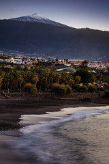 Scenic sunset view of Punta Brava down Playa Maria Jimenez beach with Pico del Teide volcano in the background, the highest point above sea level in the Canary Islands