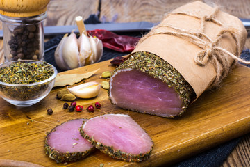 Piece of smoked Ham with garlic and spice on wooden background. Rustic style