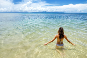 Fototapeta na wymiar Young woman sitting in clear water on Taveuni Island, Fiji