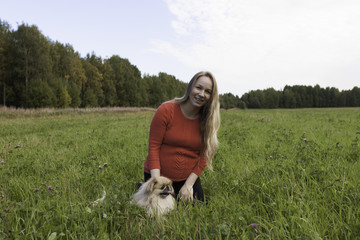 Pregnant girl walking in nature and smiling