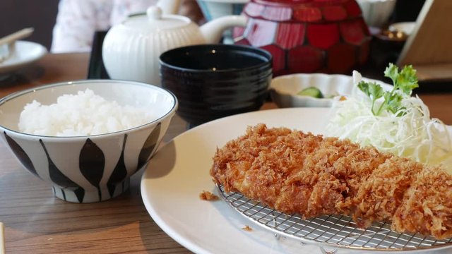 Tonkatsu a Japanese dish which consists of a breaded, deep-fried pork cutlet served with shredded cabbage miso soup and bowl of rice.