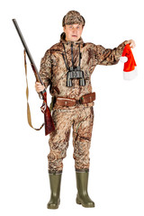 male hunter with double barreled shotgun holding santa hat