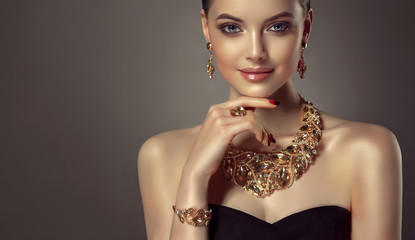 Beautiful girl with set jewelry .   Woman in a necklace with a ring, earrings and a bracelet. Beauty and accessories.
