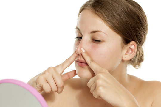 A young woman touching her nose with her fingers