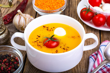 White bowl with cream soup of lentils, tomatoes and mozzarella