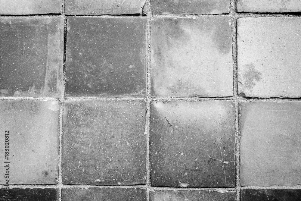 Poster close-up of a dusty and smooth paving viewed from above in black and white with vignetting.
