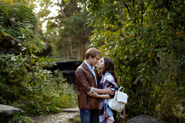 loving couple on walk in the park. the man and the woman stand, look each other in the face and embrace.close up.