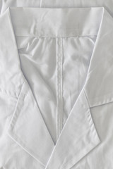 Top view image of folded doctor white coat. Medical and health care concept.