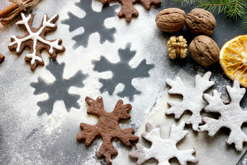 Christmas cookies in the shape of snowflakes posypanny flour and scattered on the table, spices. Food. Background closeup.