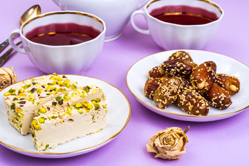 Oriental sweets-halva and dates on bright pink background