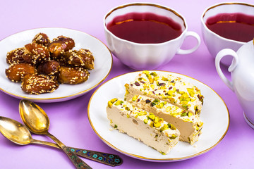 Oriental sweets-halva and dates on bright pink background