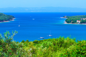 Wonderful romantic summer afternoon landscape panorama coastline Adriatic sea. Boats and yachts in harbor at magical clear transparent turquoise water. Cres island. Croatia. Europe.