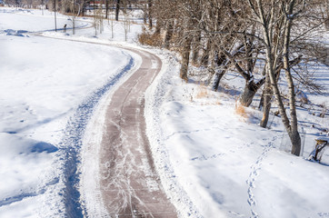 Winding Footpath Cleared through a Snowy Riverside Park on a Sunny Winter Day. Calgary, AB, Canada.