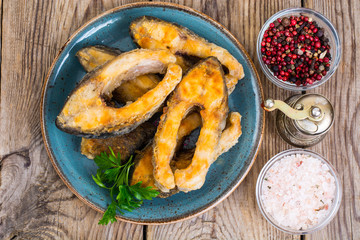 Pieces of fried fish on blue plate