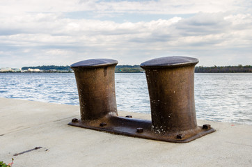 Naklejka premium Rusty Bollards on a Dock along the Potomac River in Alexandria, VA on a Cloudy Day.
