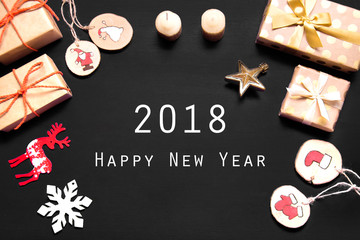 Fototapeta na wymiar New year's background on a black desk decorated with toys, presents, Santa Claus, snowman. Bright colored background symbolizes the new year celebration. Great useful template to wright words down.