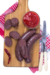 Homemade blood sausage with tomato sauce on wooden board
