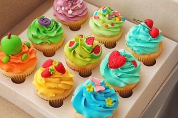 Tasty colorful cupcakes in open paper box