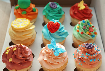 Tasty colorful cupcakes in open paper box