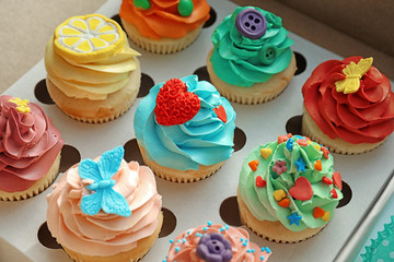 Tasty colorful cupcakes in open paper box
