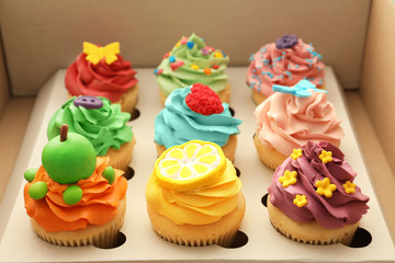 Tasty colorful cupcakes in open paper box