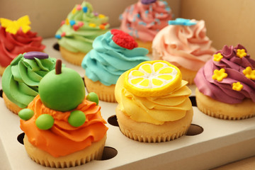 Tasty colorful cupcakes in open paper box