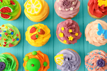 Tasty colorful cupcakes on wooden background
