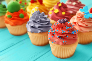 Tasty colorful cupcakes on wooden background
