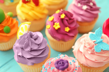 Tasty colorful cupcakes on table, closeup