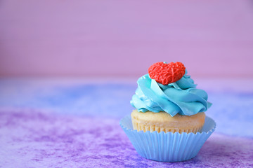 Tasty bright cupcake on color background