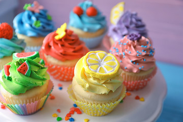 Stand with tasty bright cupcakes, closeup
