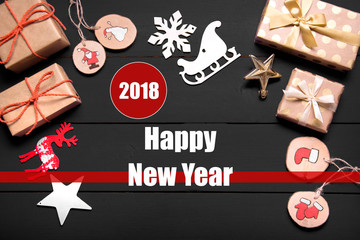 New year's background on a black desk decorated with toys, presents, Santa Claus, snowman. Bright colored background symbolizes the new year celebration. Great useful template to wright words down.