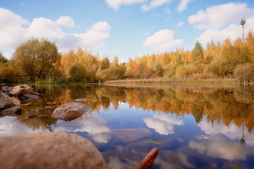 Lake in autumn colors. Rocks, blue sky Space