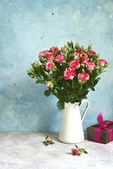 Bouquet of pink roses in a white vintage pitcher or jug.