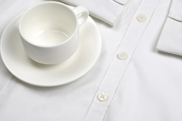 empty white coffee Cup and saucer on a white shirt