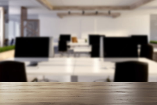Computers on wooden office desks blurred
