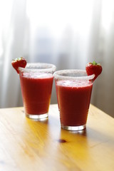 Roter Erdbeer-Smoothie mit Dekoration am Glas