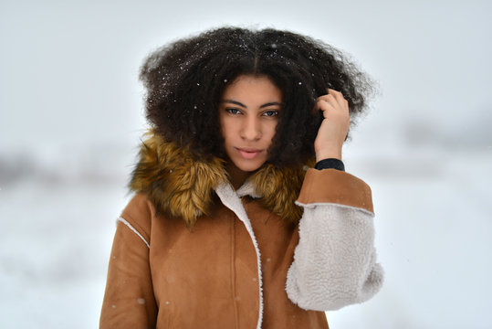 Femme afro-am&eacute;ricaine dans les v&ecirc;tements d'hiver sur fond d'hiver.