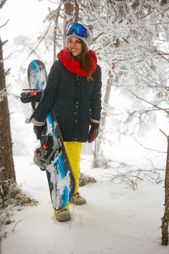 girl snowboarder going through in the fog winter forest