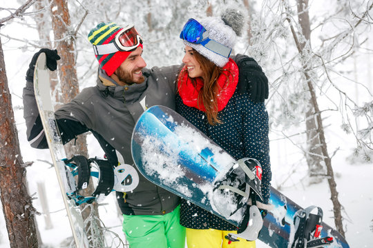 couple snowboarder having fun in the fog winter forest