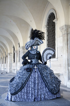 Venice Carnival masks and  comtumes under the arcade of the Doges Palace St. Mark's Square