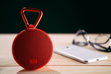 Red wireless speaker on wooden background